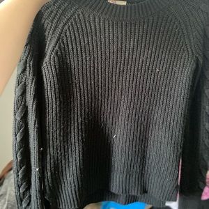 black sweater with cross detailing on sleeves